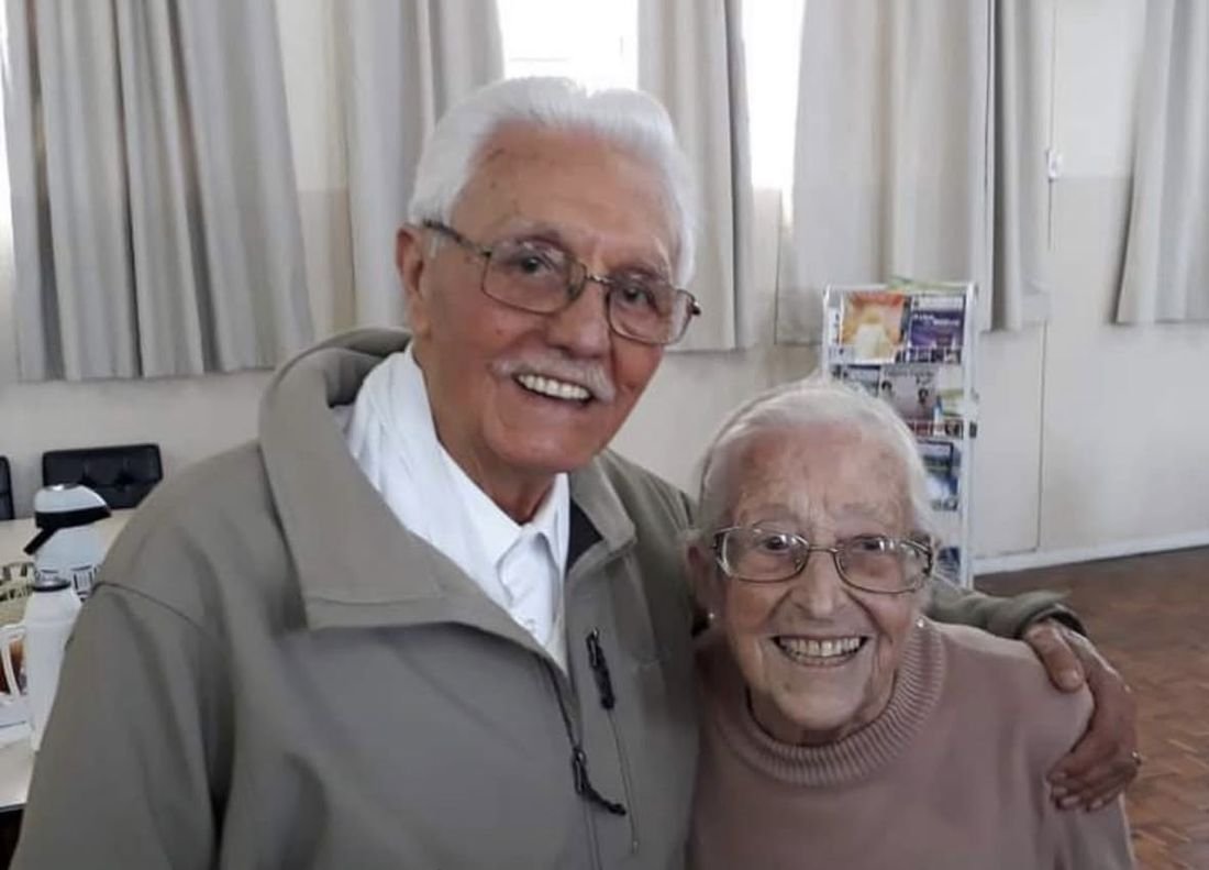 Dona Rony e Seu Barros, já idosos, abraçados e sorridentes no salão do Centro